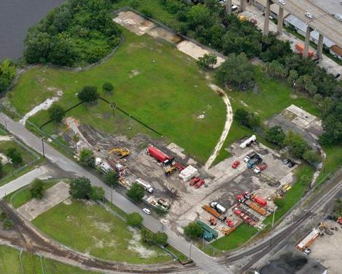 Aerial view of equipment yard with automobiles, railroad tracks, and parking lot